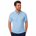 A man wearing a light blue short-sleeve polo shirt with a small white embroidered logo on the left chest, paired with dark navy pants, against a plain white background.