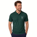 A man wearing a dark green short-sleeve polo shirt with a small white embroidered antelope logo on the left chest, paired with navy pants, against a plain white background.