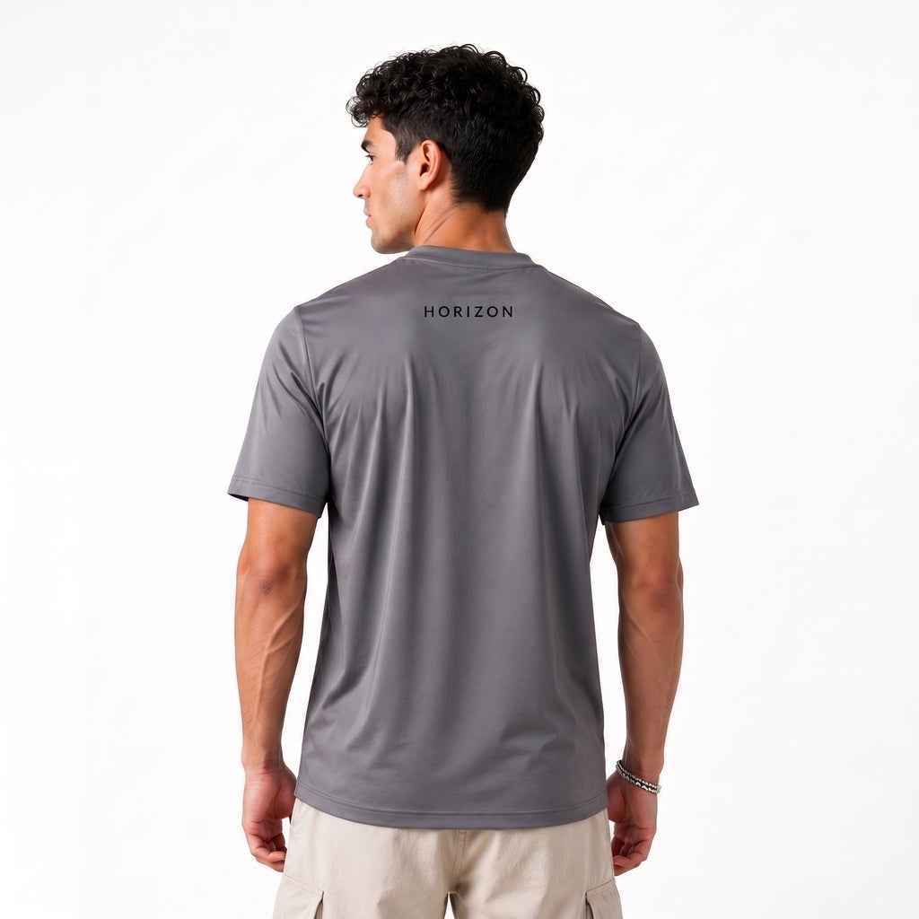 A man viewed from the back wearing a dark gray short-sleeve t-shirt with 'HORIZON' printed in black on the upper back, paired with light beige cargo pants, against a plain white studio background.