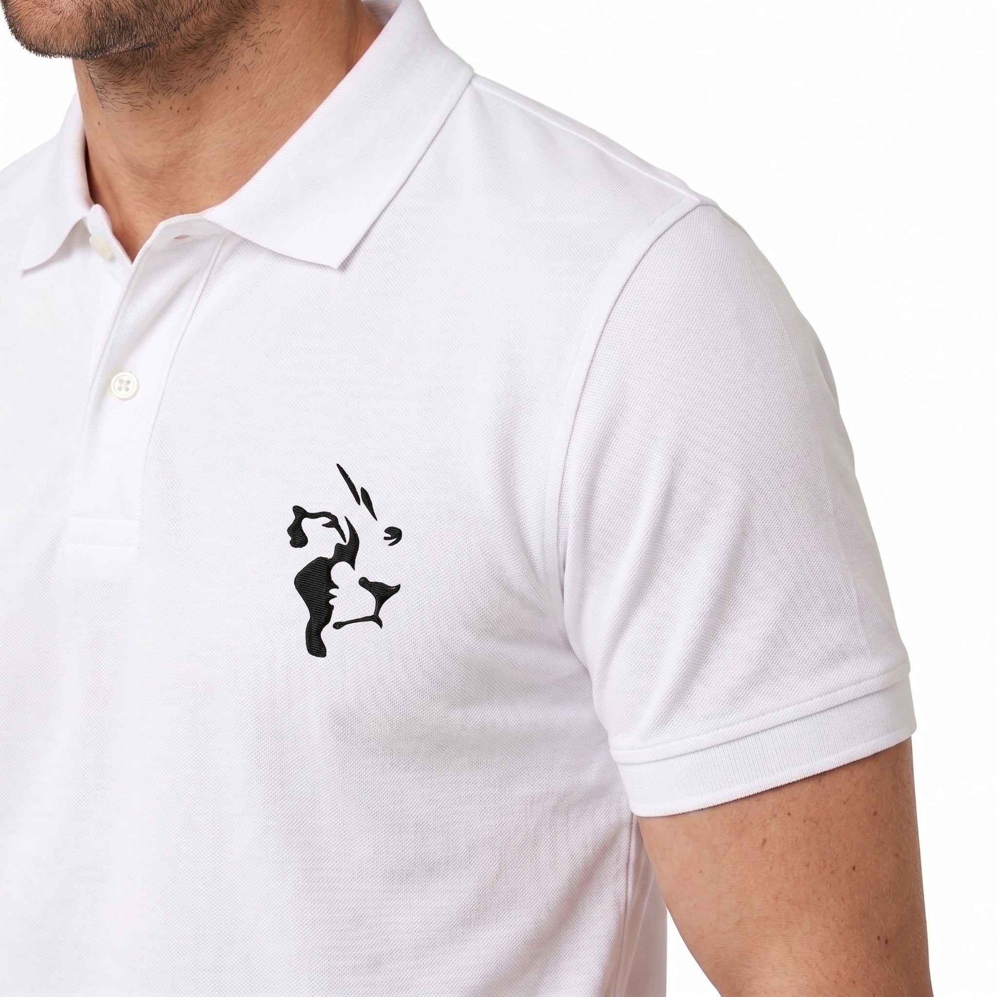 A close-up of a man wearing a white short-sleeve polo shirt with a black stylized graphic printed on the left chest.