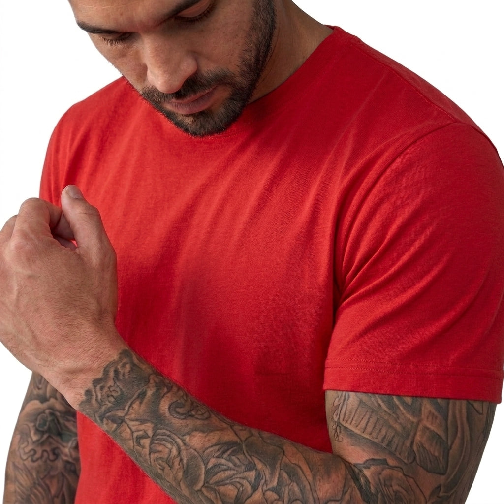 A close-up of a man wearing a solid red short-sleeve crewneck t-shirt, showing the fabric texture and fit on his chest and arm against a white background.
